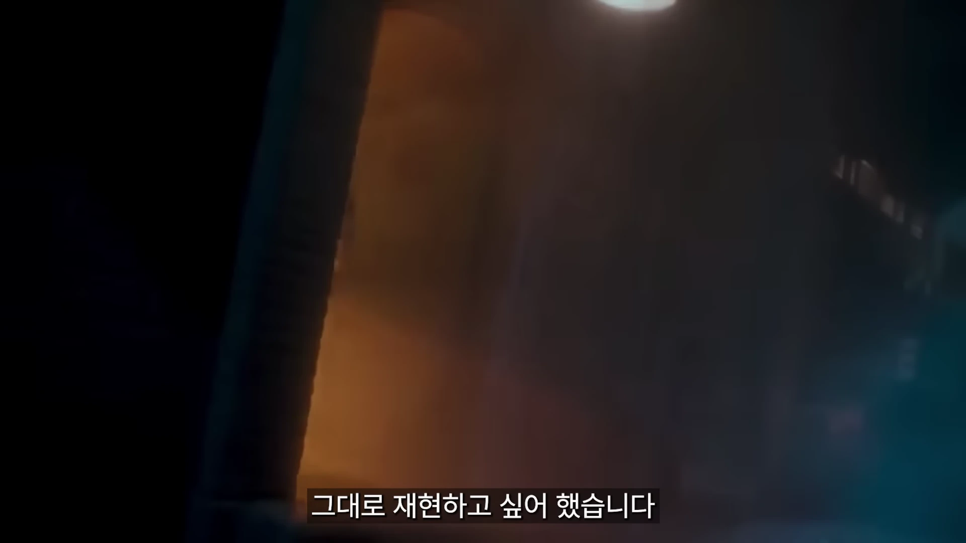 어두운 배경 속에 빛이 비치는 실루엣 장면과 함께 '그대로 재현하고 싶어 했습니다'라는 자막이 하단에 표시된 영상 캡처 화면.