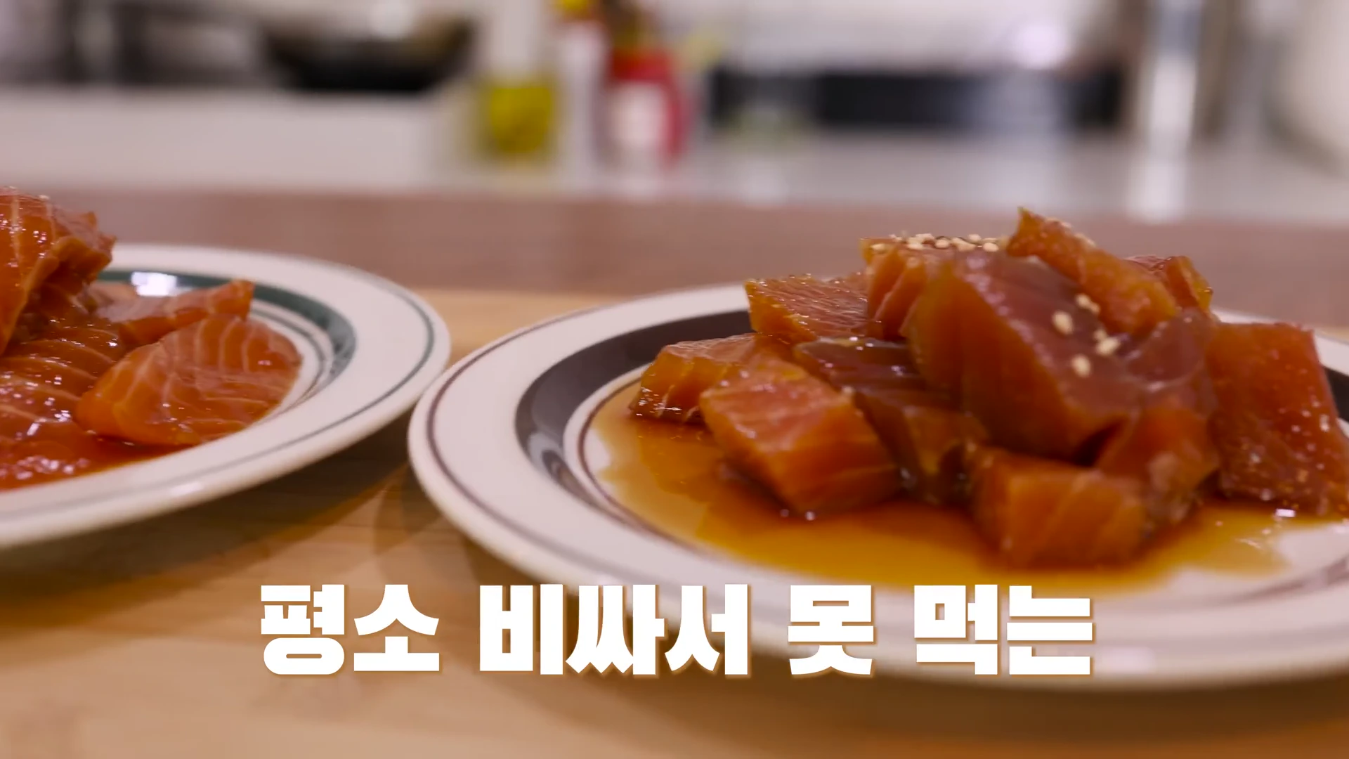 흰색 접시 위에 놓인 간장에 절여진 연어와 참치 파지들이 클로즈업되어 있으며, 화면 하단에는 한국어 자막이 강조되어 있다.