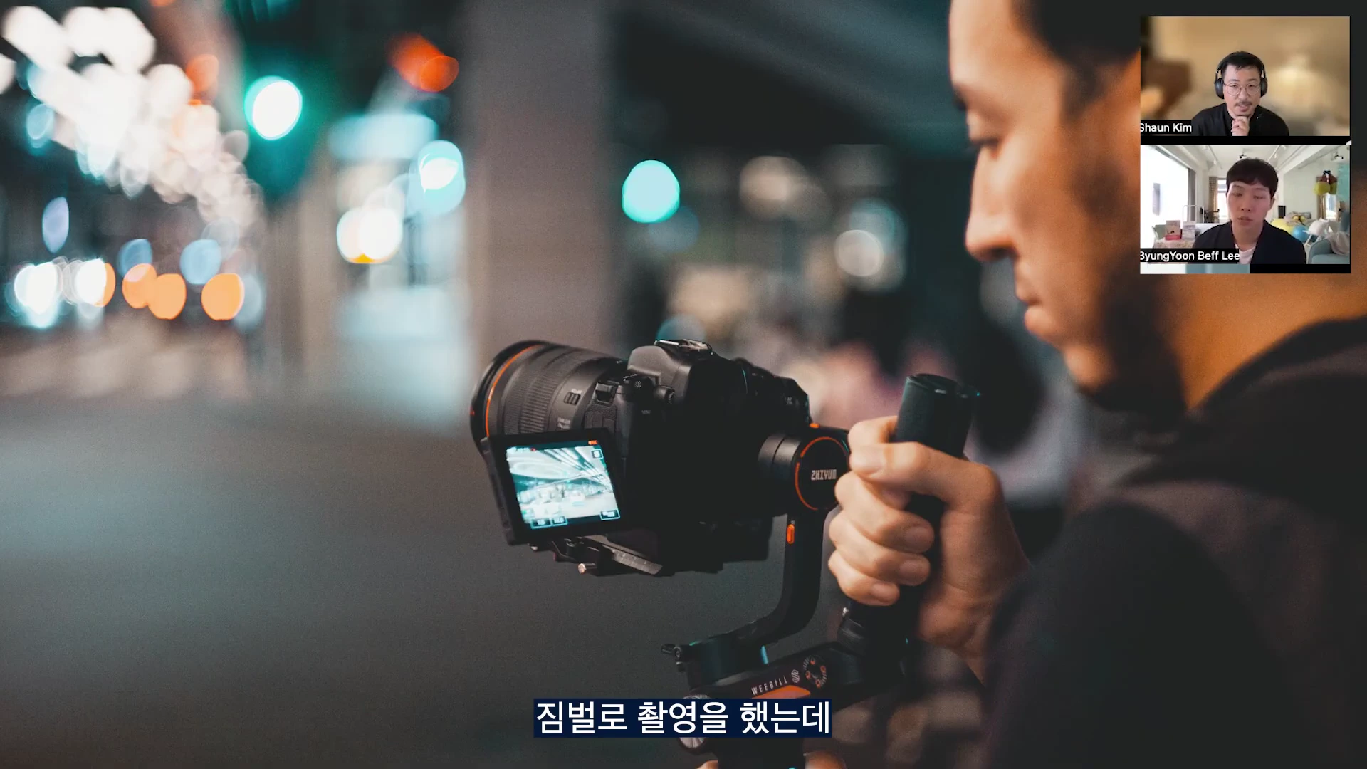 짐벌에 장착된 카메라를 손으로 들고 촬영하는 모습이 담긴 영상 속 화면이며, 우측 상단에는 화상 대담을 나누는 두 사람의 모습이 작게 나타나 있습니다.