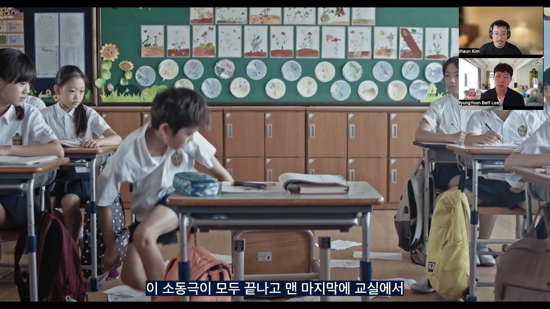 영화 장면이 담긴 영상 프레임 속에서 학생들이 교실에 앉아 있는 모습과 우측 상단에 두 명의 인터뷰어가 화면으로 연결된 화상 인터뷰 형식의 모습.