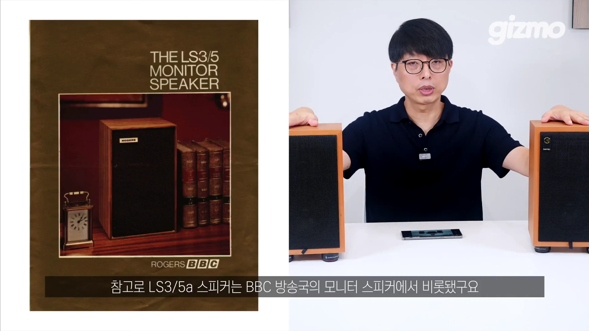 안경을 쓴 남성이 양손으로 스피커 두 대를 잡고 있으며, 왼쪽 화면에는 고전적인 영국 로저스사 스피커가 담긴 빈티지한 사진이 인쇄된 포스터가 보입니다.