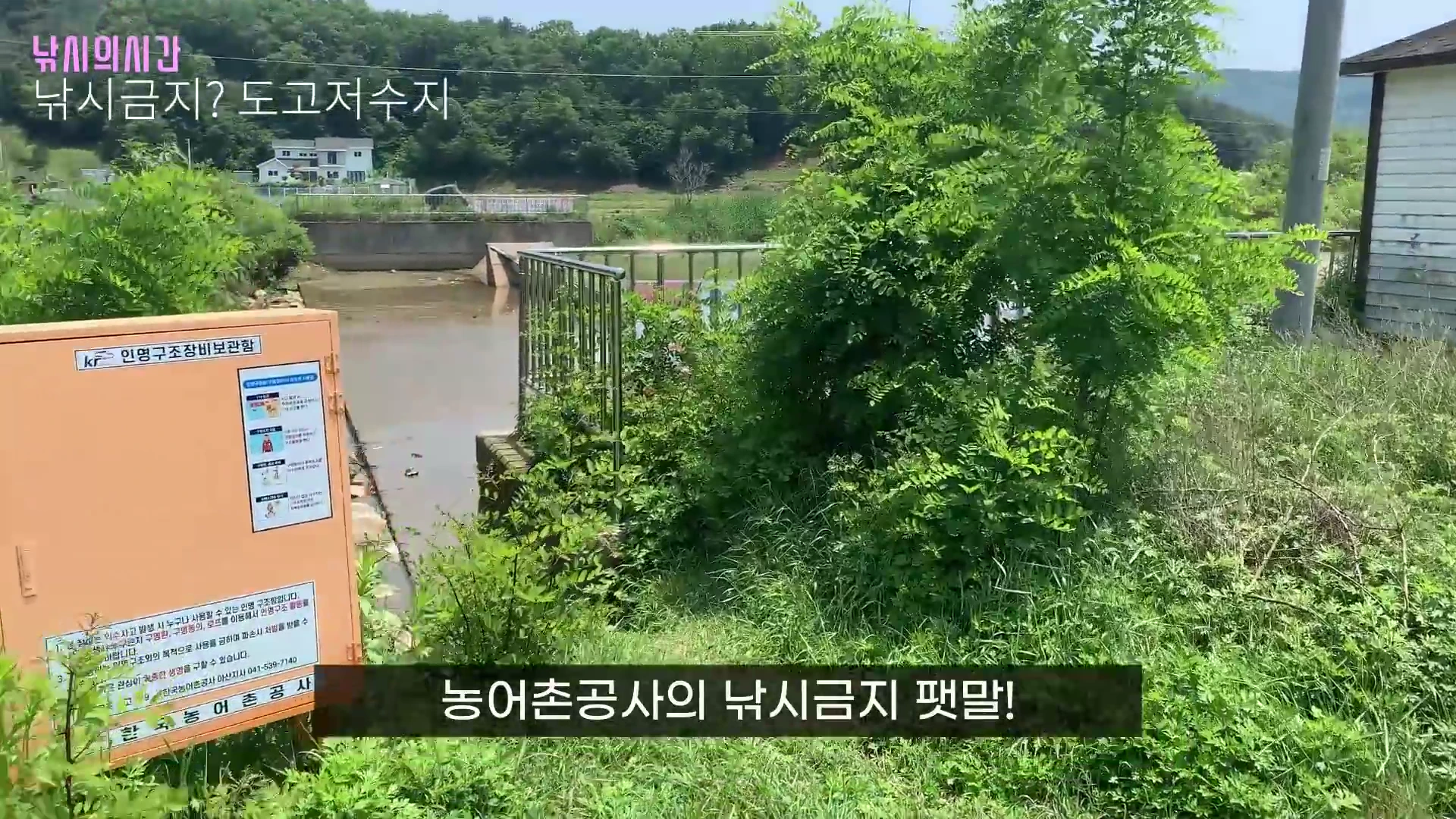 도고저수지 현장의 주황색 인명구조장비함과 울타리 주변의 모습이 보이며 화면 하단에 농어촌공사의 낚시금지 팻말이라는 자막이 표시되어 있습니다.