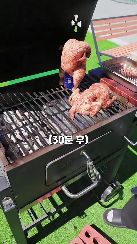 바비큐 그릴 위에 비어캔을 끼워 세운 생닭 한 마리와 일반적인 직화 구이용 생닭 한 마리가 나란히 놓여 있는 모습