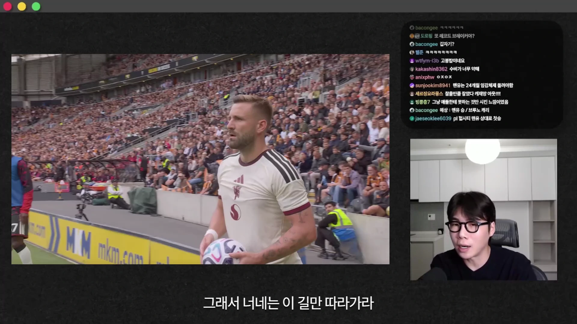 축구 경기 중 공을 들고 이동하는 선수와 그 옆에 실시간 채팅창, 화면을 보고 말하는 남성 스트리머가 보이는 영상 캡처 화면입니다.