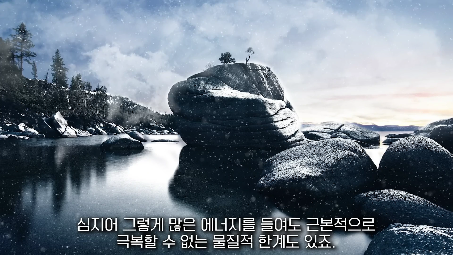 눈 덮인 거대한 바위와 작은 나무가 있는 호수 풍경 위에 한국어 자막이 겹쳐진 영상 화면입니다.