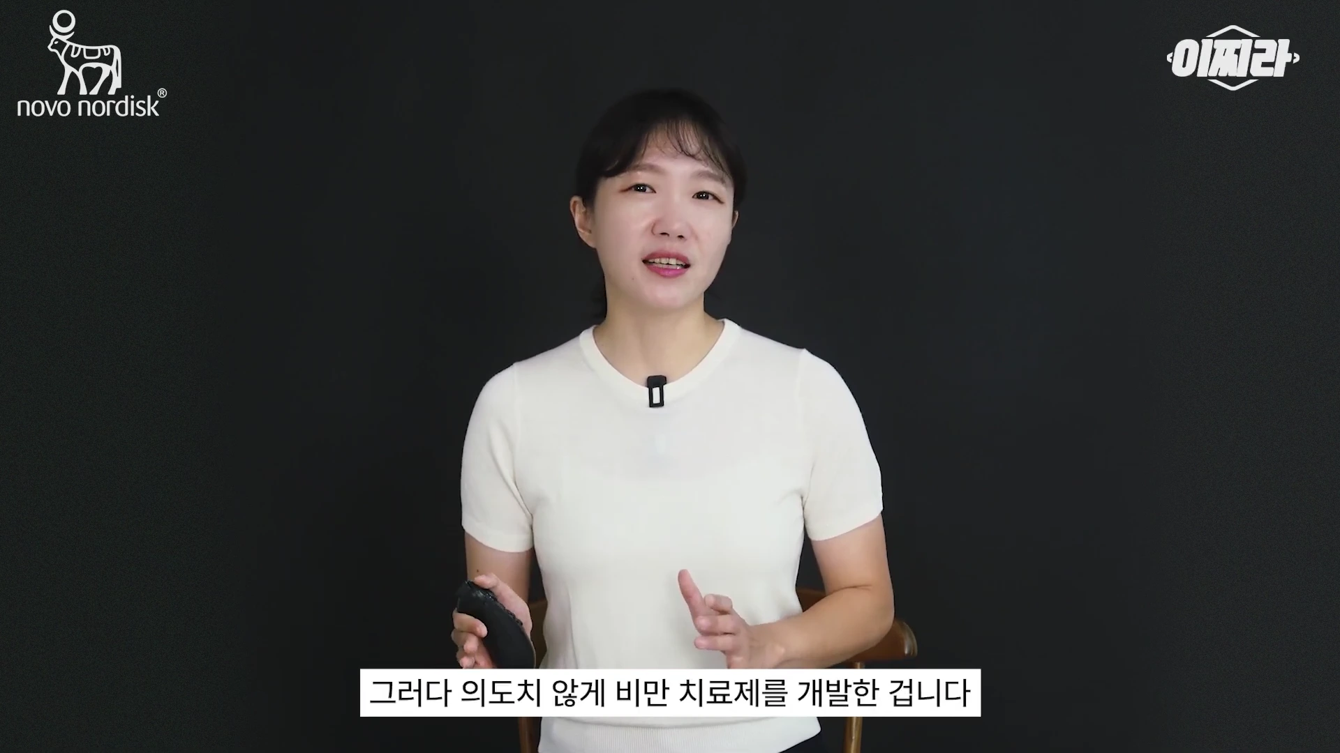 검은 배경 앞에서 흰색 반팔 티셔츠를 입은 여성 발표자가 손짓을 하며 말을 하고 있고 화면 하단에는 자막이 달려 있습니다.
