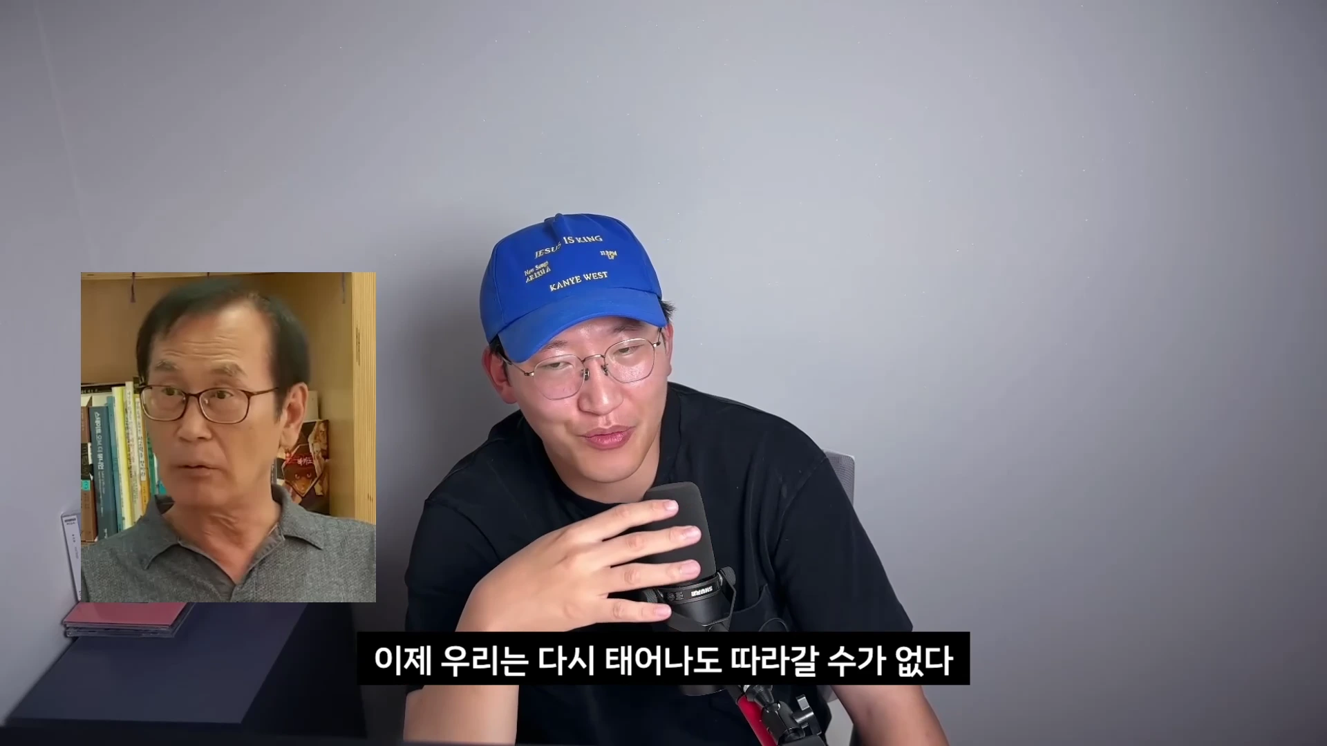파란색 야구 모자를 쓴 남성이 마이크 앞에서 이야기를 하고 있고, 화면 왼쪽에는 다른 노년 남성이 등장하는 작은 영상이 겹쳐져 있습니다.