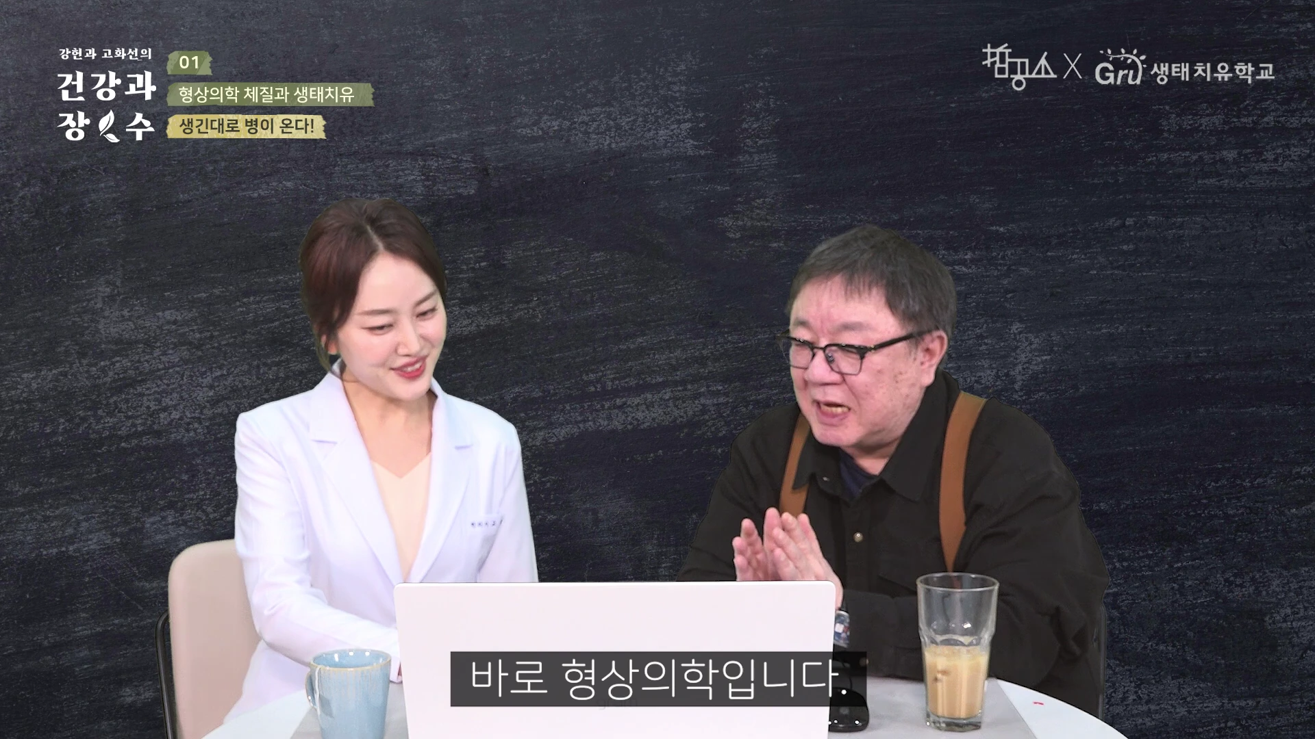 흰색 가운을 입은 여성과 안경을 쓴 남성이 테이블 앞에 앉아 이야기를 나누고 있는 모습이 담긴 영상 캡처 화면입니다. 화면 상단에는 프로그램 제목과 '생긴 대로 병이 온다!'는 문구가 적혀 있고, 하단 자막으로 '바로 형상의학입니다.'라고 표기되어 있습니다.