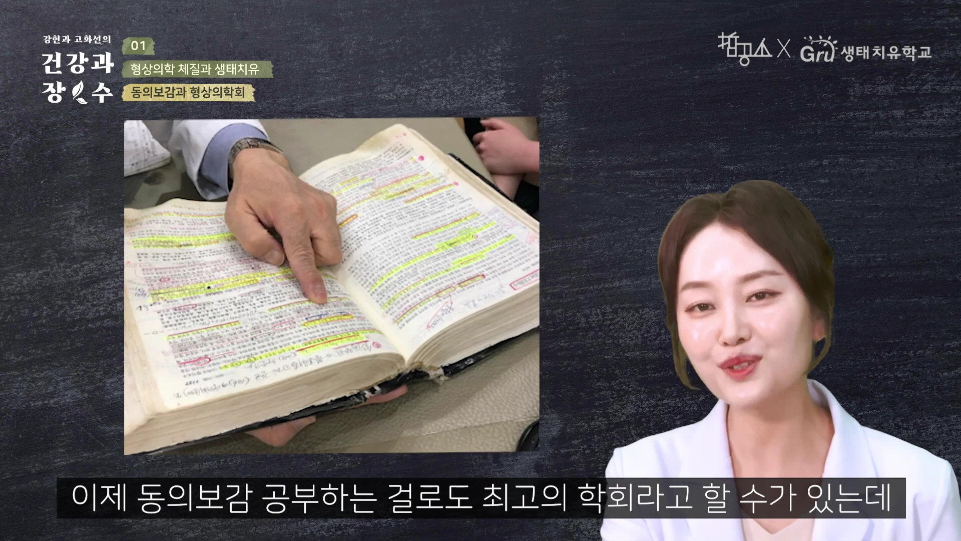 흰색 가운을 입은 한의사가 손가락으로 빽빽하게 필기된 동의보감 책의 특정 부분을 가리키고 있으며, 오른쪽에는 한 여성이 이야기하는 모습이 담긴 영상 캡처 화면.