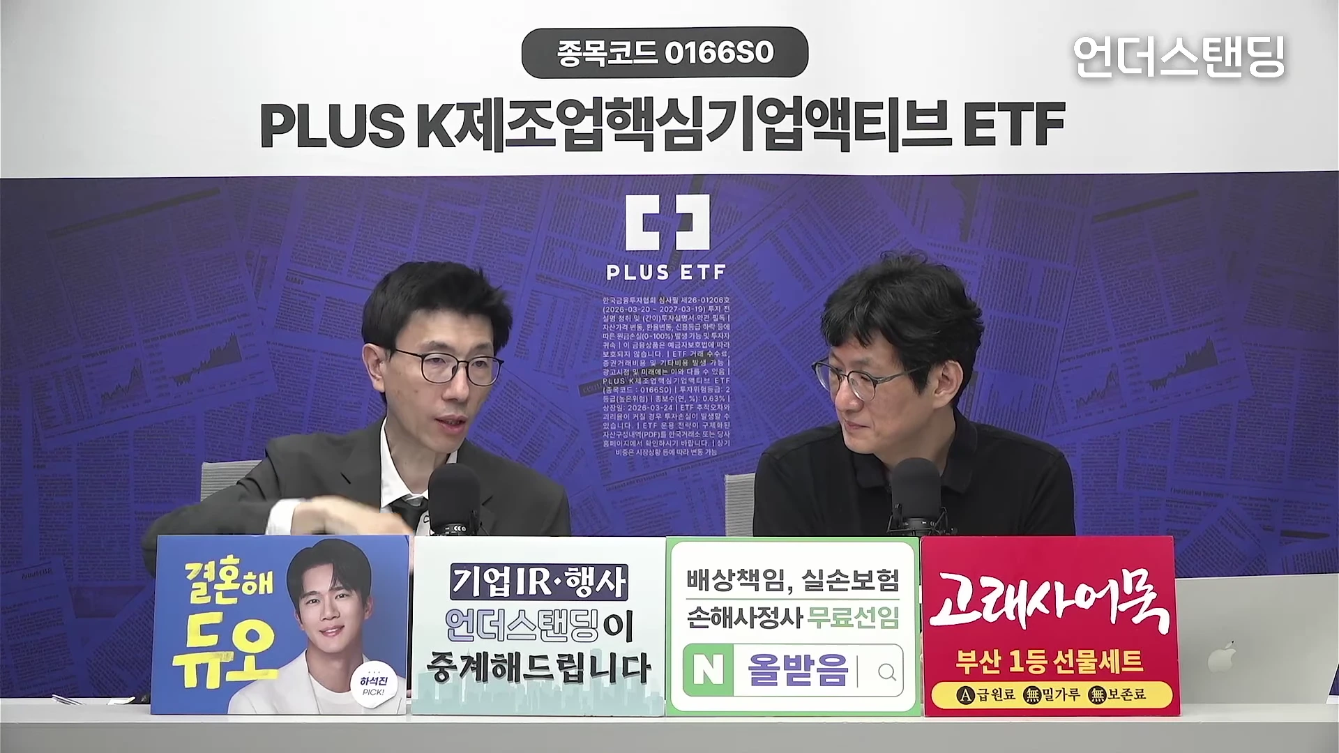 두 명의 남성이 스튜디오 테이블에 앉아 마이크를 앞에 두고 대화를 나누고 있다. 배경에는 'PLUS K제조업핵심기업액티브 ETF'라는 문구와 투자 관련 안내문이 게시되어 있고, 책상 앞에는 다양한 광고판이 나란히 놓여 있다.