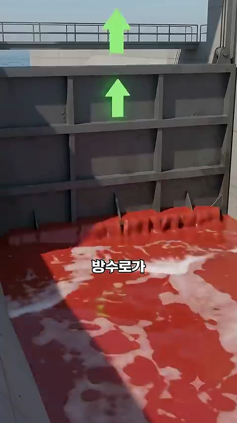 금속 수문이 위로 올라가면서 붉은 물이 쏟아져 나오는 모습이 담긴 그래픽 영상입니다.