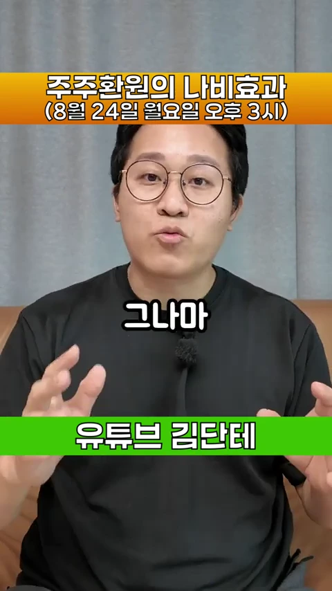 안경을 쓴 남성이 검은색 티셔츠를 입고 카메라를 정면으로 바라보며 손동작과 함께 이야기하고 있는 영상의 한 장면입니다.