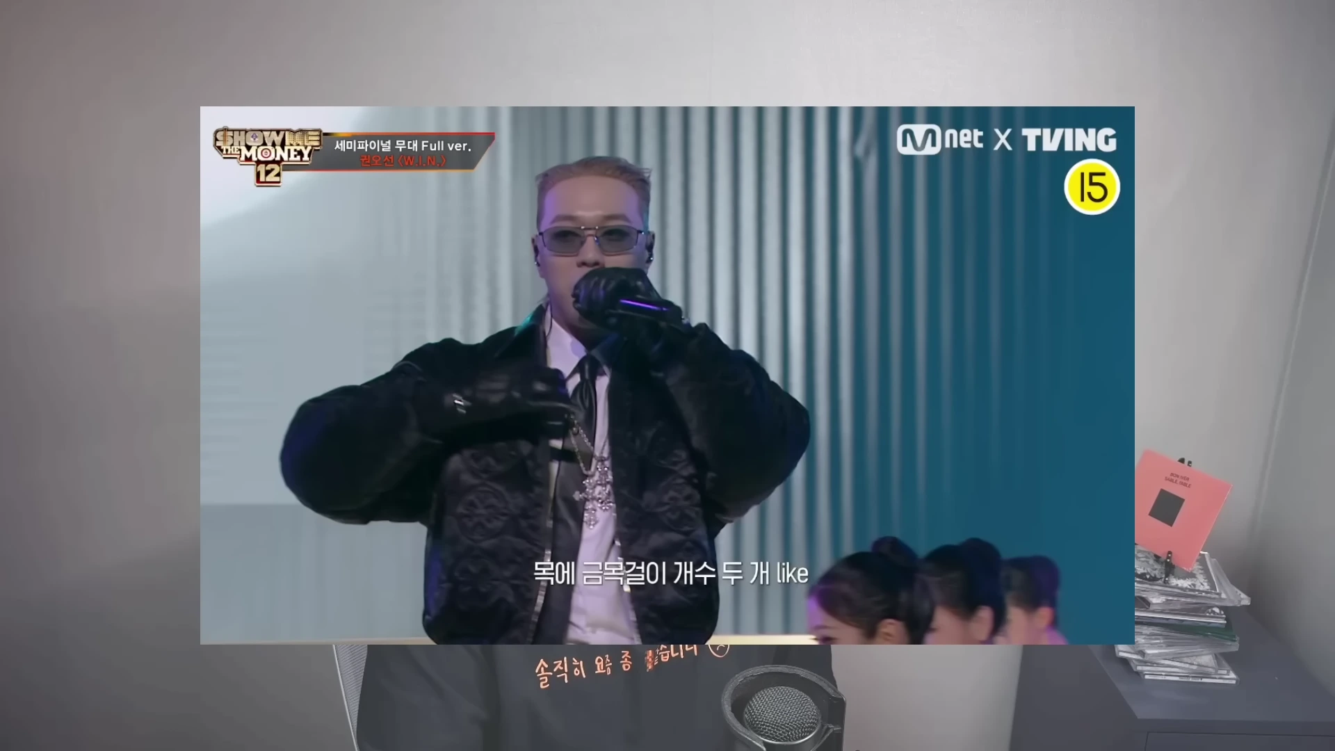 선글라스를 낀 남성 래퍼가 무대 위에서 공연하는 모습이 담긴 방송 화면 캡처로, 상단에는 엠넷 쇼미더머니 로고와 노래 제목이 표시되어 있습니다.