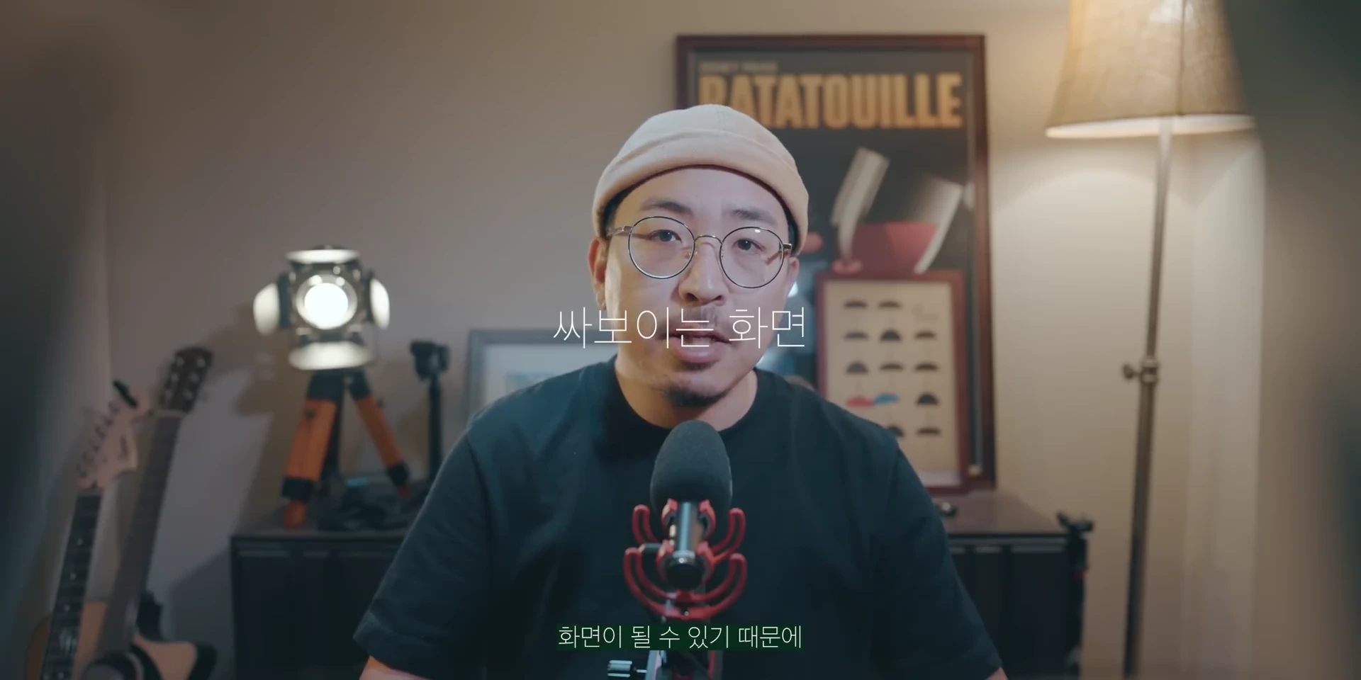 안경과 베이지색 비니를 쓴 남성이 마이크 앞에 앉아 정면을 바라보며 이야기하고 있으며, 화면 중앙에는 '싸보이는 화면'이라는 자막이 떠 있다.