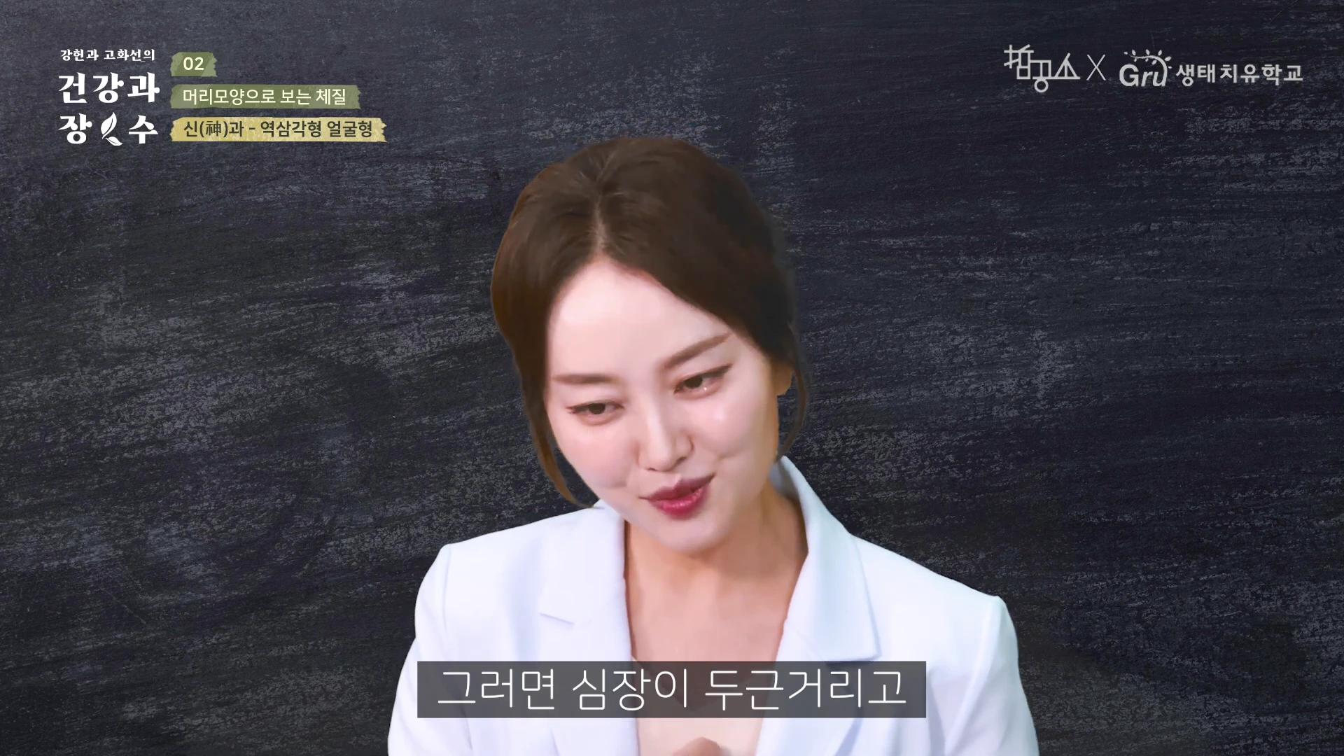 흰색 정장을 입고 말하고 있는 여성의 상반신이 담긴 영상 캡처 화면이며, 화면 왼쪽 상단에는 프로그램 제목과 신(神)과-역삼각형 얼굴형이라는 문구가 적혀 있습니다.