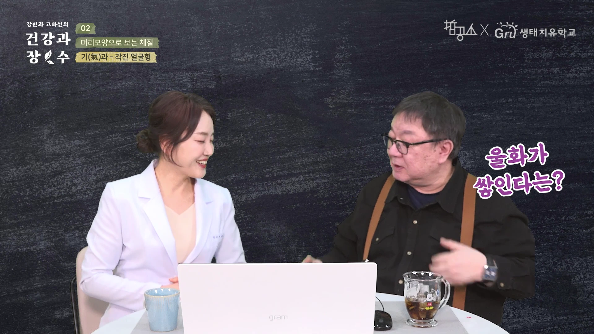 흰색 재킷을 입은 여성과 검은색 셔츠를 입은 남성이 테이블 앞에 앉아 대화하는 스튜디오 촬영 화면이며, 화면 왼쪽 상단에는 제목이, 오른쪽에는 '울화가 쌓인다는?'이라는 문구가 표시되어 있다.