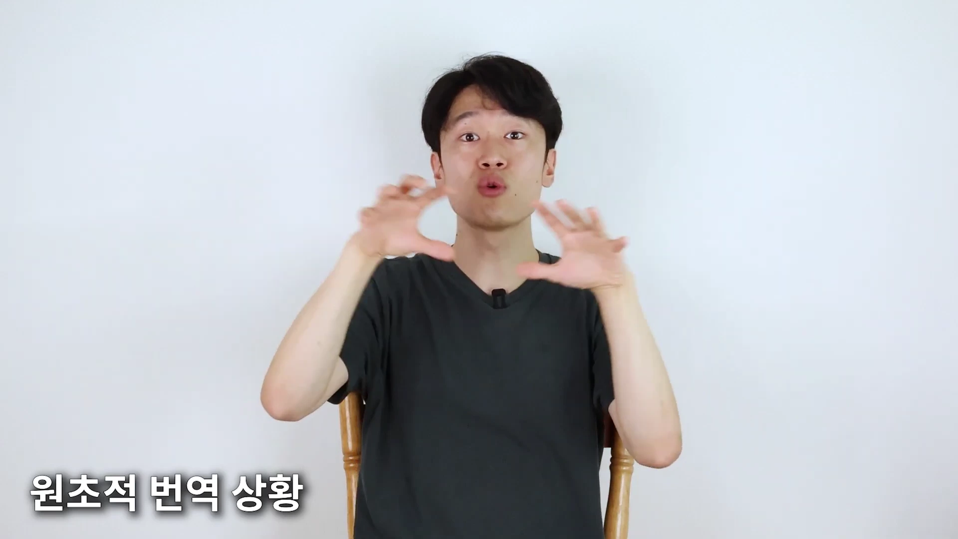 흰색 배경의 스튜디오에 앉아 두 손을 움직이며 설명하는 남성 출연자와 화면 하단에 표시된 '원초적 번역 상황'이라는 자막.