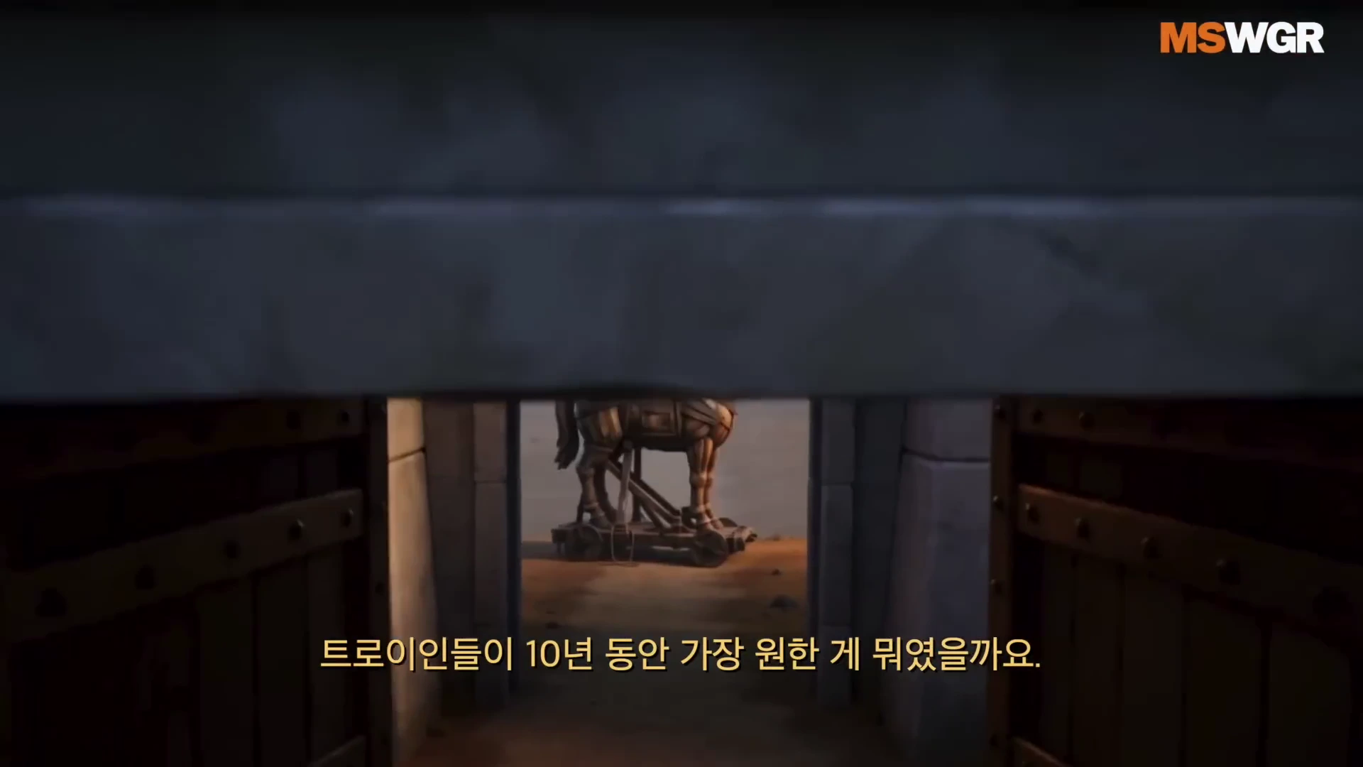 닫힌 성문 틈으로 멀리 놓인 트로이 목마가 보이는 장면을 담은 애니메이션 스타일의 영상 화면