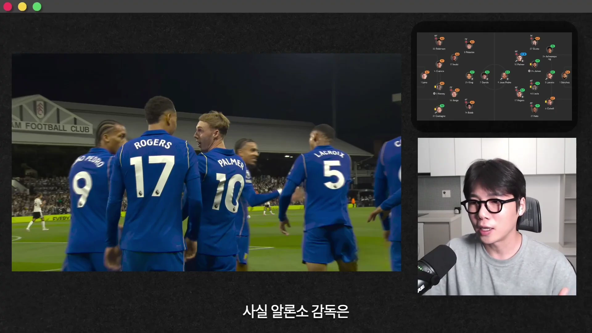 축구 경기 중 파란색 유니폼을 입은 선수들이 모여 기뻐하는 장면과 그 옆에 전술 배치도를 보여주는 스크린, 그리고 마이크를 잡고 설명하는 진행자가 화면에 함께 구성되어 있습니다.