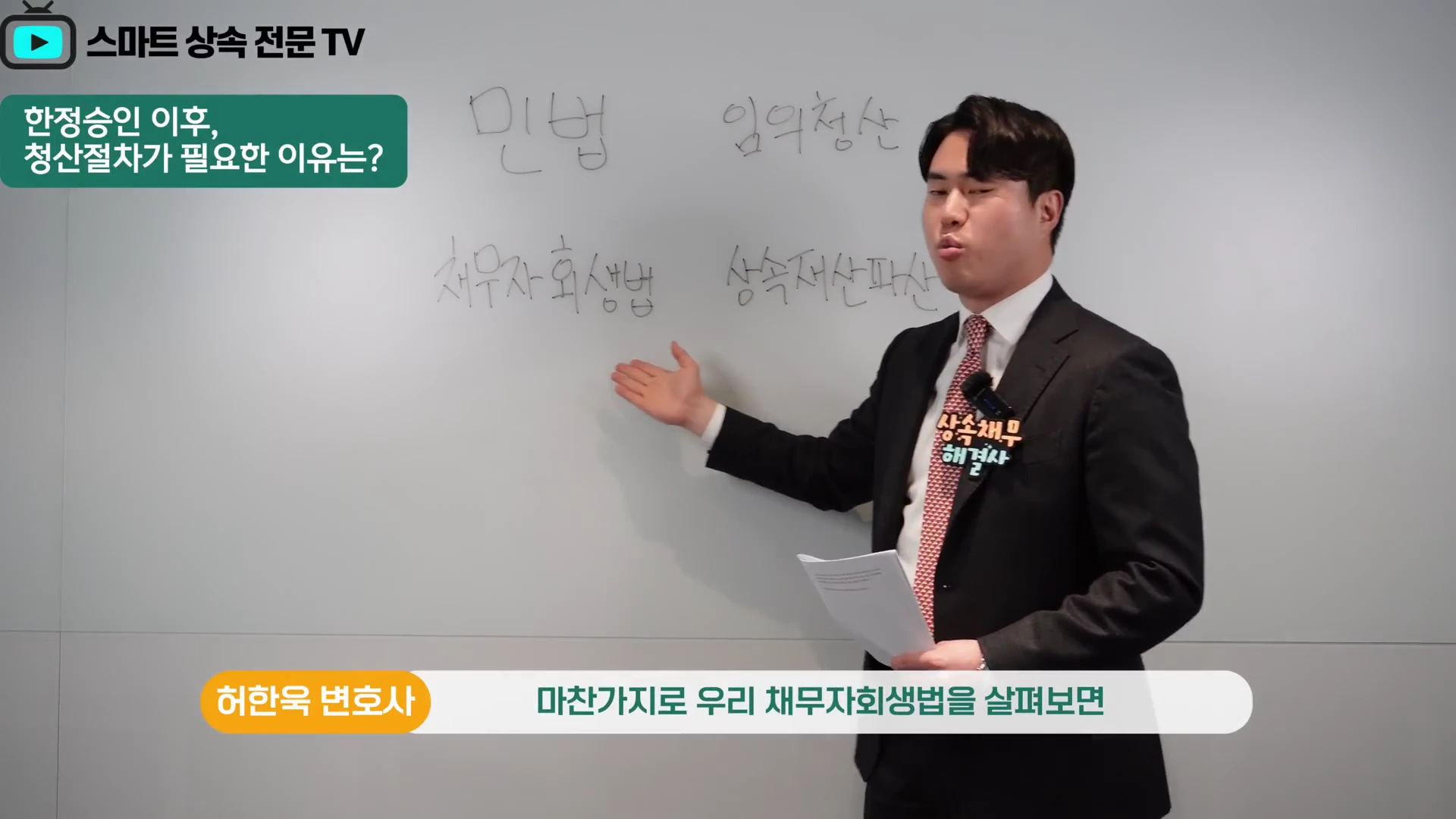 정장을 입은 남성이 흰색 보드 앞에 서서 '민법, 임의청산'과 '채무자회생법, 상속재산파산'이라고 적힌 글씨를 손으로 가리키며 설명하고 있습니다.