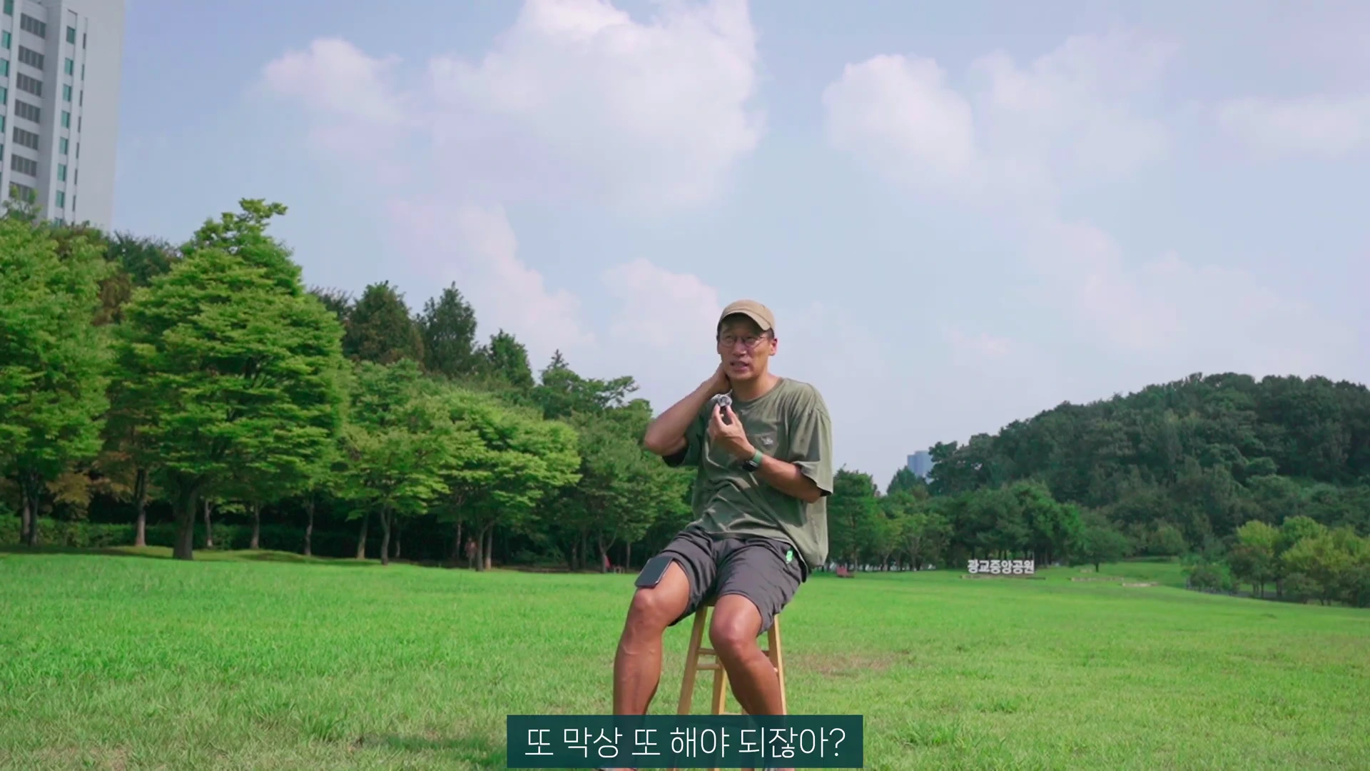 푸른 잔디밭 위에 놓인 의자에 앉아 한 남성이 캡 모자와 편안한 옷차림으로 야외 인터뷰를 하고 있다.