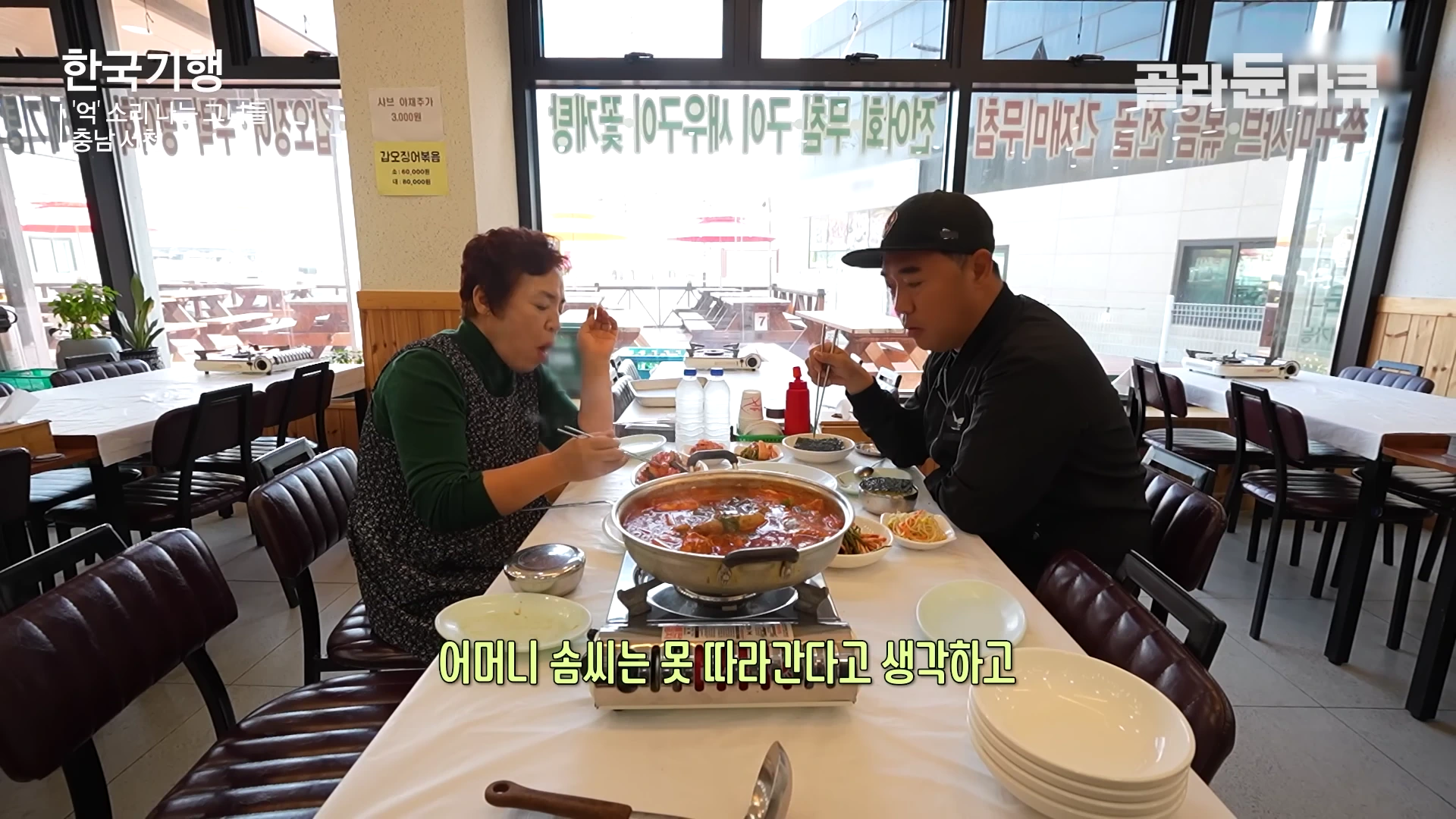 음식점이 있는 실내 테이블에서 한 중년 여성과 남성이 마주 앉아 식사를 하고 있는 모습