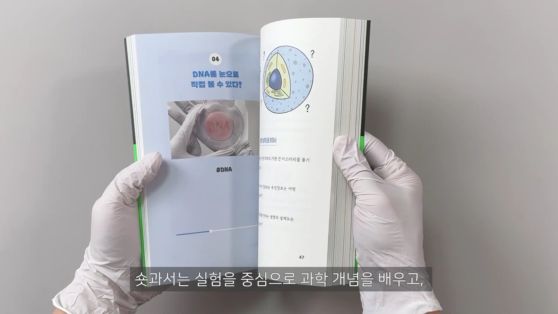 흰 장갑을 낀 두 손이 펼치고 있는 과학 책의 내지. 왼쪽 페이지에는 'DNA를 눈으로 직접 볼 수 있다?'라는 질문과 DNA 실험 사진이 있고, 오른쪽 페이지에는 세포 구조 일러스트와 설명글이 담겨 있다.