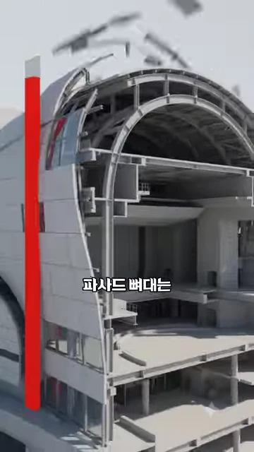 공연장의 내부 구조와 비정형 외벽 뼈대를 보여주는 3D 그래픽 영상으로, 강조된 빨간색 수직선과 함께 '파사드 뼈대는'이라는 자막이 적혀 있습니다.