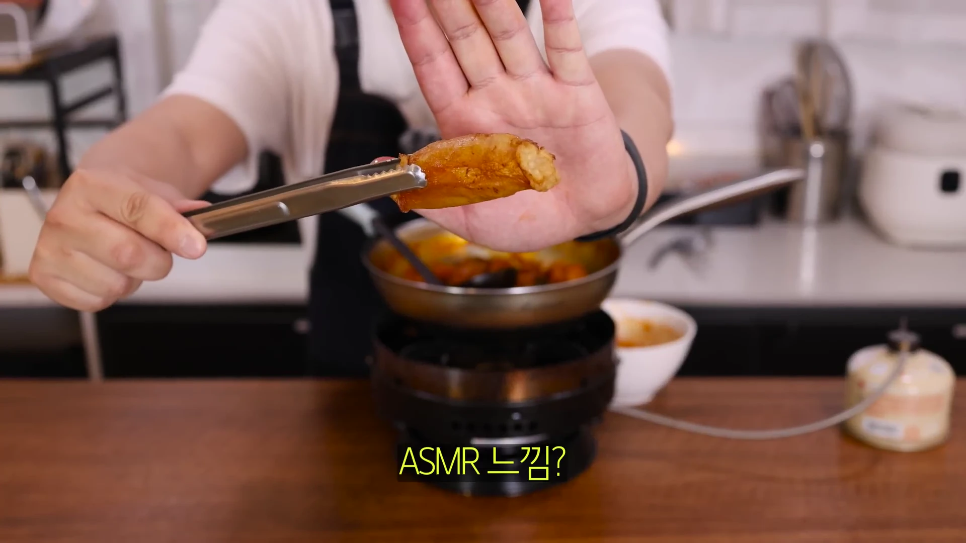 한 사람이 집게로 구워진 노릇한 대창을 들고 손바닥을 펼쳐 보여주고 있으며 하단에는 ASMR 느낌?이라는 자막이 적혀 있다.