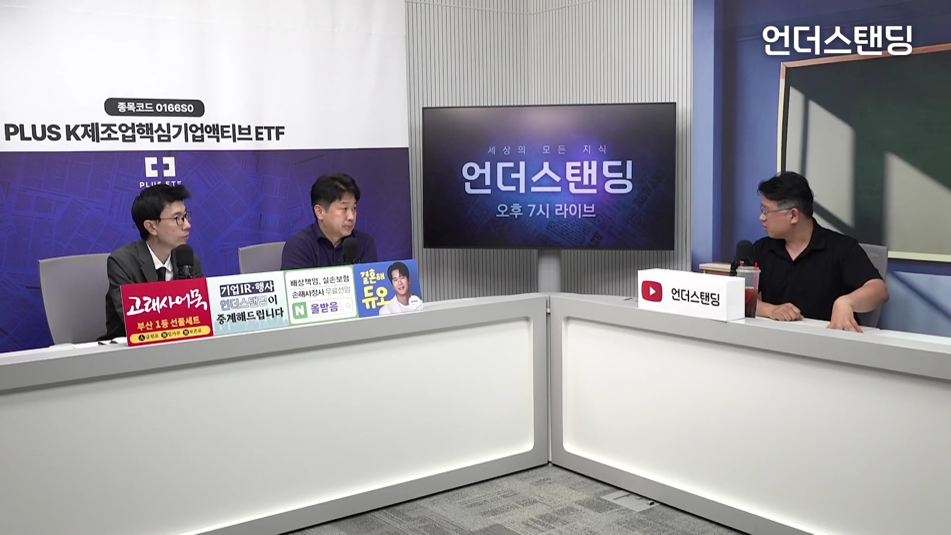 두 명의 출연자와 한 명의 진행자가 스튜디오 테이블에 앉아 대화를 나누는 모습.
