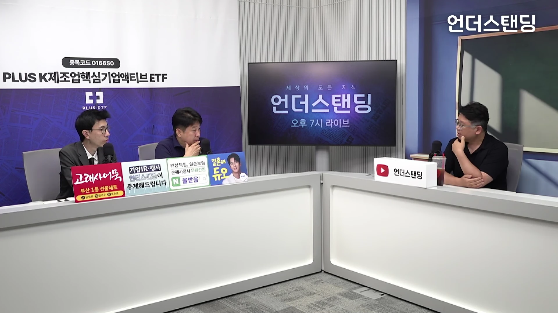 두 명의 출연자와 한 명의 진행자가 스튜디오의 밝은색 책상에 앉아 대화를 나누고 있는 모습입니다. 배경에는 브랜드 이름이 적힌 화면이 있고, 책상 앞에는 몇 가지 작은 안내 문구와 로고가 놓여 있습니다.