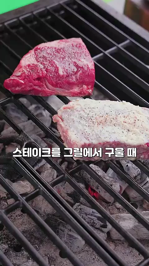 그릴 위에 일반 생고기 한 점과 분유 가루로 뒤덮인 스테이크 한 점이 나란히 놓여 구워지고 있는 모습이다.