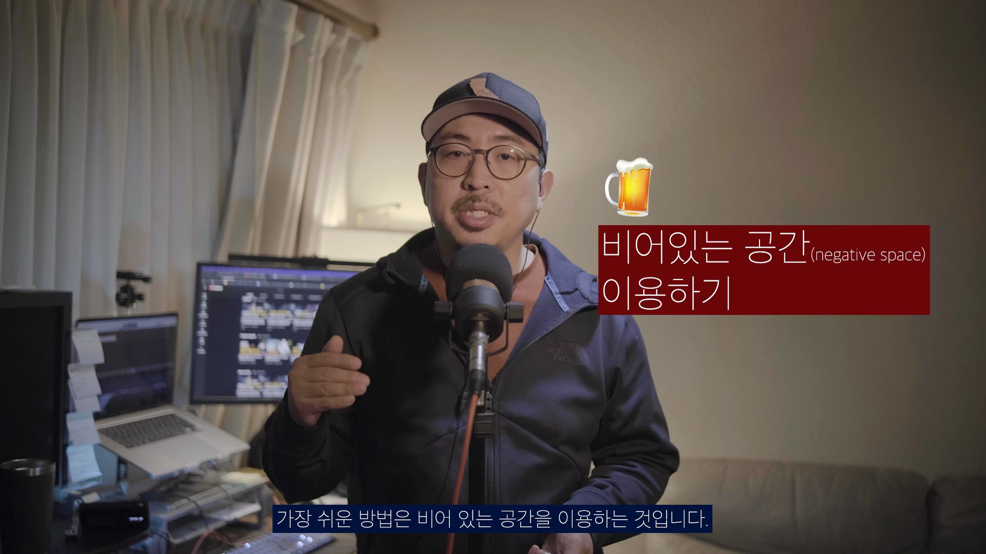 안경을 쓰고 모자를 쓴 남성이 마이크 앞에 앉아 이야기하고 있으며, 화면 오른쪽에는 '비어있는 공간 이용하기'라는 문구와 맥주잔 아이콘이 떠 있다.