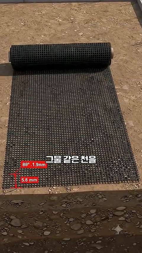 그물 형태의 격자 구조를 가진 검은색 산업용 자재가 바닥에 펼쳐져 있고, 규격 수치가 표시된 그래픽이 겹쳐져 있는 모습