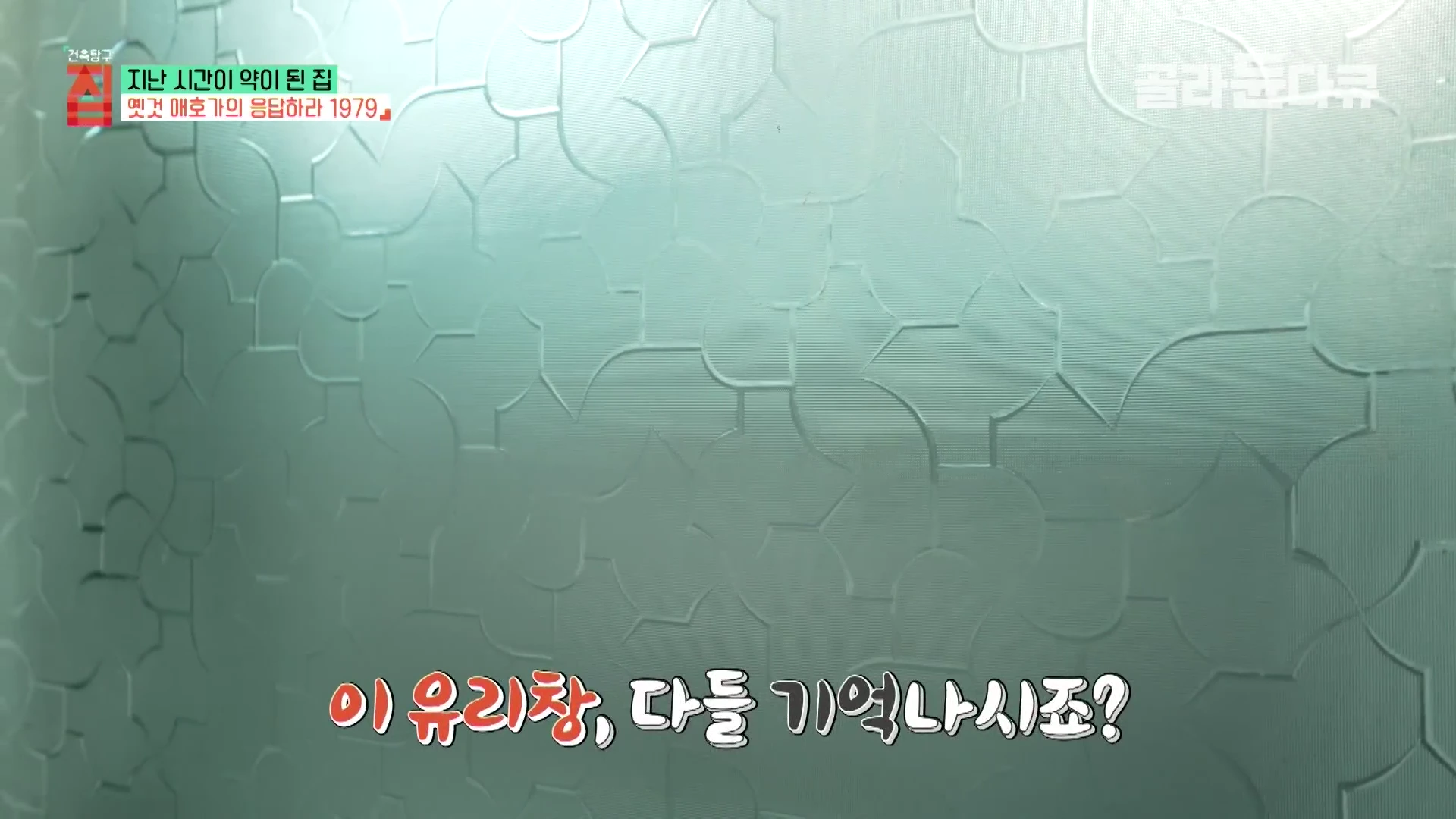 복잡하고 반복적인 기하학적 문양이 새겨진 불투명한 유리창 표면을 가까이서 촬영한 모습.