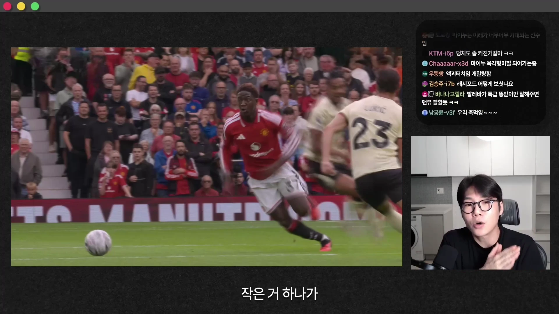 축구 경기 중 맨체스터 유나이티드 유니폼을 입은 선수가 그라운드를 뛰고 있는 경기 영상 화면과 우측 하단에 마이크를 잡고 설명하는 남성의 모습이 담긴 방송 화면