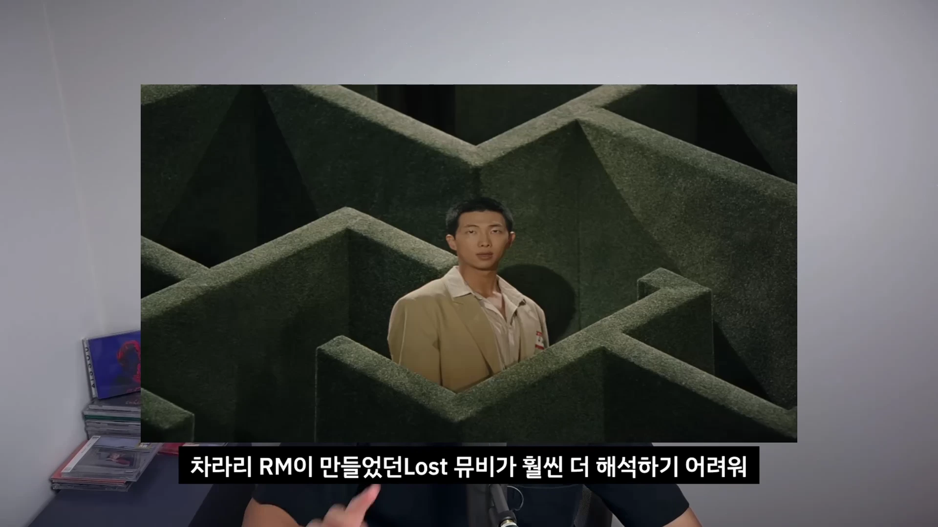 한 남성이 미로 속에 서 있는 장면이 담긴 뮤직비디오 영상이 화면 중앙에 배치되어 있고, 그 아래에는 '차라리 RM이 만들었던 Lost 뮤비가 훨씬 더 해석하기 어려워'라는 한글 자막이 적혀 있다.