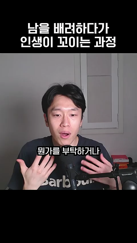 마이크 앞에 앉아 손동작을 하며 무언가를 설명하고 있는 젊은 남성이 화면 중앙에 보이며, 상단과 하단에는 한국어 자막이 삽입되어 있습니다.