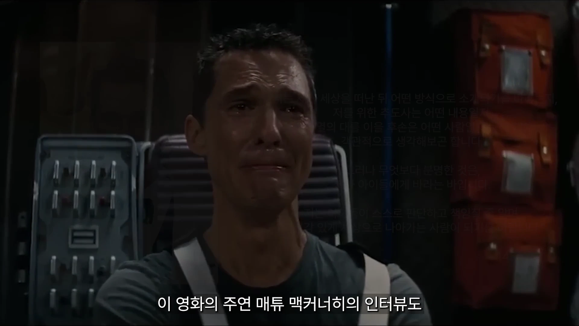 영화 속 우주선 안에서 눈물을 흘리며 영상 메시지를 보고 있는 남성 배우의 모습이 담긴 화면