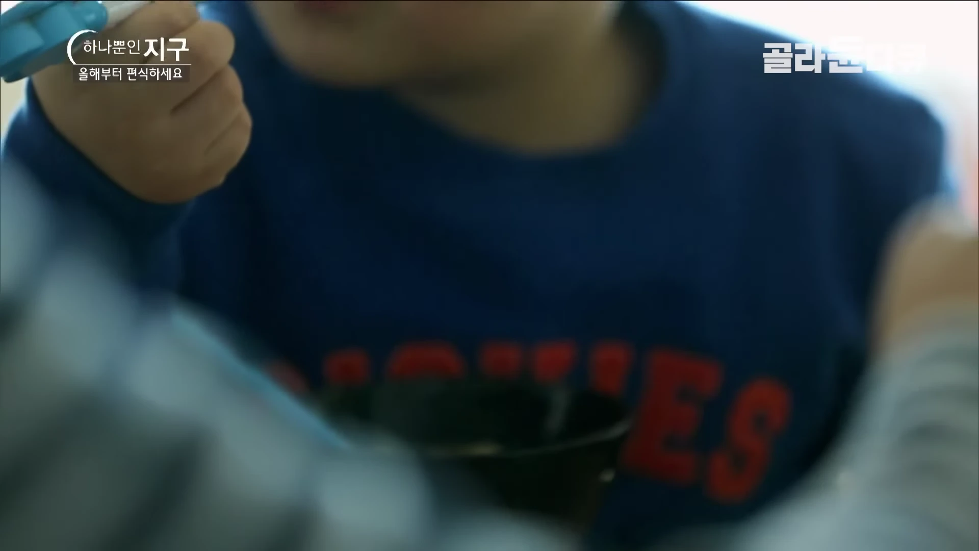 푸른색 상의를 입은 어린이가 숟가락을 들고 식사를 하는 모습이 담긴 방송 화면이며, 화면 왼쪽 상단에는 프로그램 제목과 부제가 로고 형태로 표시되어 있습니다.
