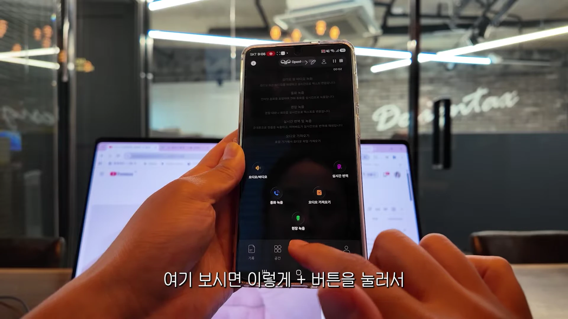 양손으로 스마트폰을 들고 있는 모습이며 화면에는 오디오 및 비디오 녹화, 통화 녹음, 실시간 번역 등의 기능을 선택할 수 있는 앱 인터페이스가 보입니다.