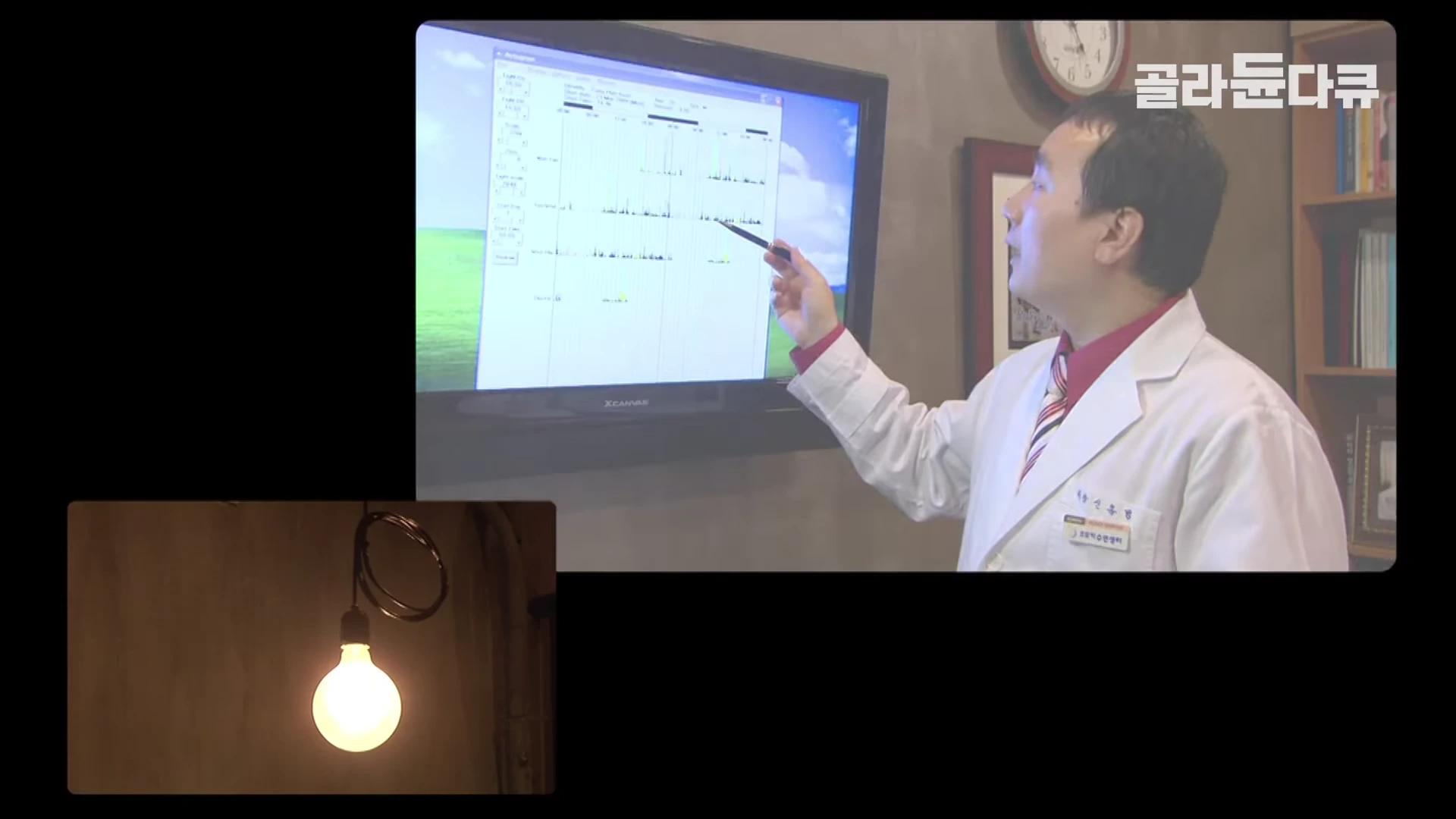 흰 가운을 입은 의사가 펜으로 모니터 속 수면 활동 기록 데이터를 가리키며 설명하고 있고, 하단에는 불이 켜진 전구가 비치고 있다.