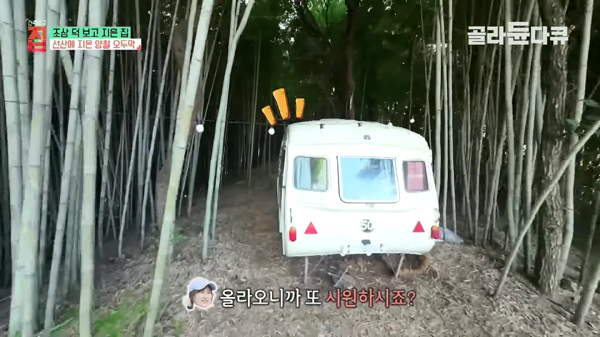 대나무 숲길 한가운데에 흰색 카라반이 세워져 있고 화면 하단에는 자막과 함께 인터뷰이의 얼굴 아이콘이 표시된 영상 캡처 화면입니다.