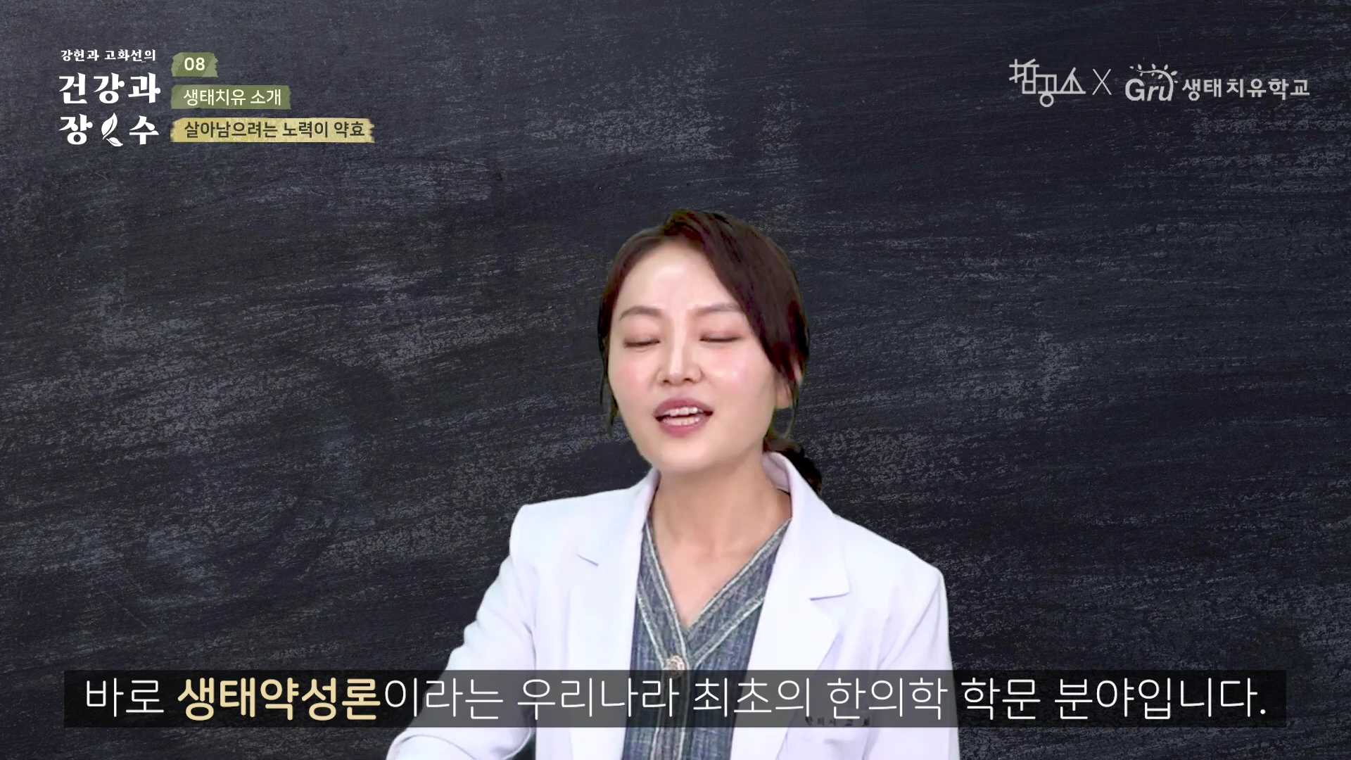 A woman in a white coat speaking in front of a dark blackboard-style screen with text overlays including the title '생태치유 소개' and the speaker's organization details.