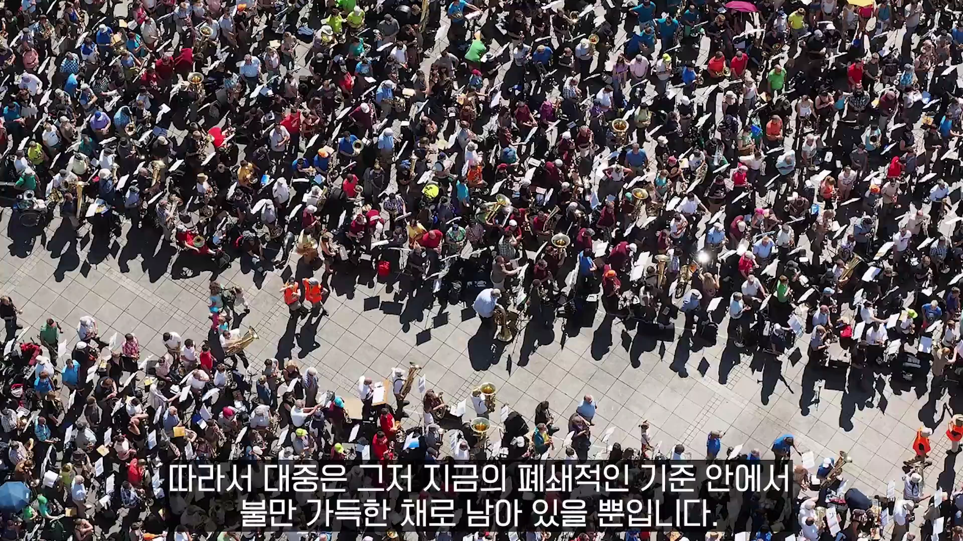 광장에 모여 악기를 연주하는 수많은 사람들을 높은 곳에서 내려다본 모습