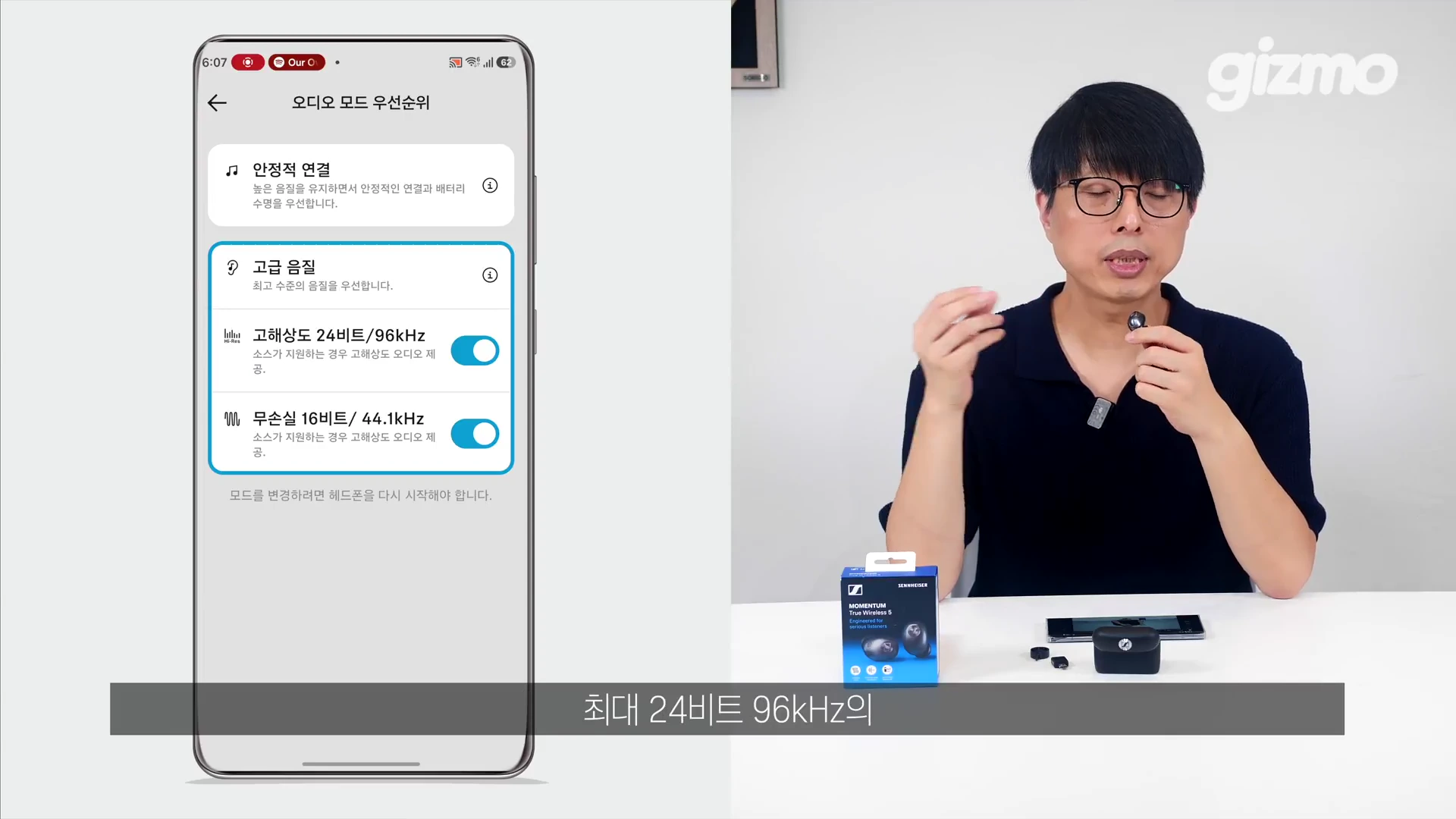 안경을 쓴 남성이 책상 앞에 앉아 무선 이어폰에 대해 설명하고 있고, 왼쪽 화면에는 스마트폰 애플리케이션의 오디오 설정 메뉴가 표시되어 있습니다.
