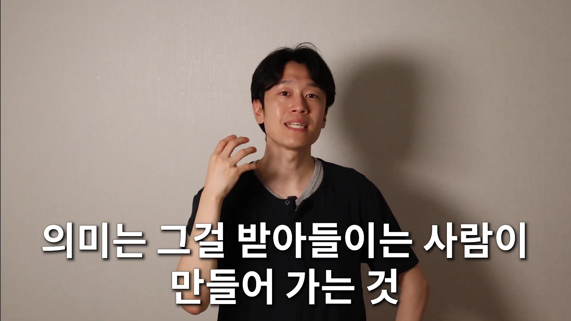 한 남성이 카메라를 향해 말하며 손짓하는 영상 화면에 '의미는 그걸 받아들이는 사람이 만들어 가는 것'이라는 자막이 하단에 배치되어 있습니다.