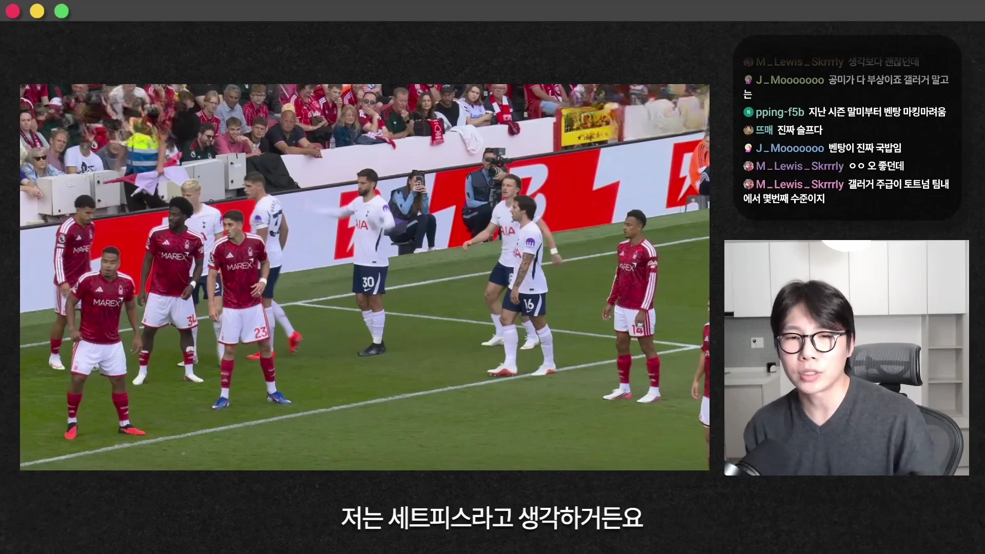 축구 경기 중 프리킥 상황에서 선수들이 수비벽을 세우고 있는 경기장면과 그 옆에 안경을 쓴 남성이 앉아 이야기하는 모습이 담긴 유튜브 영상 화면입니다.