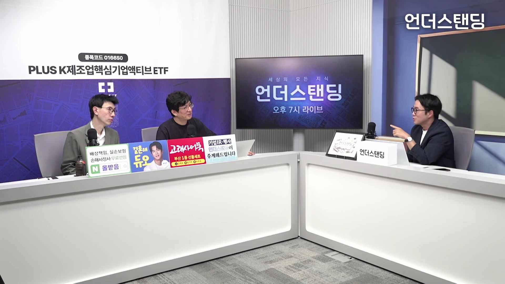 두 명의 진행자와 한 명의 게스트가 화이트 톤의 스튜디오 테이블에 앉아 대화를 나누고 있는 모습이 담긴 방송 화면입니다.