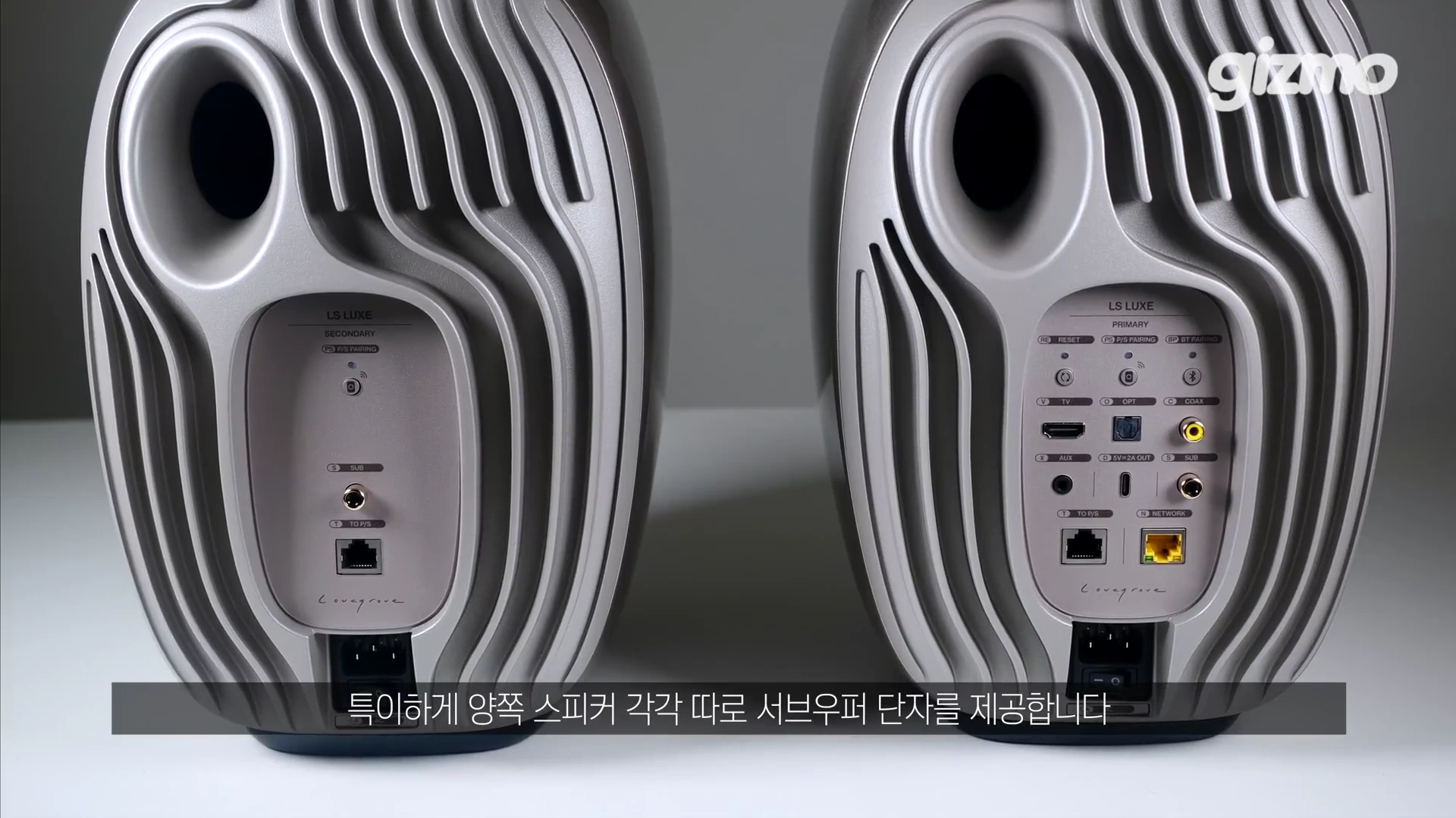 KEF LS Luxe 스피커 두 대의 후면부가 나란히 배치되어 있으며, 방열판 디자인과 다양한 입출력 단자 및 전원 포트가 강조되어 보입니다.